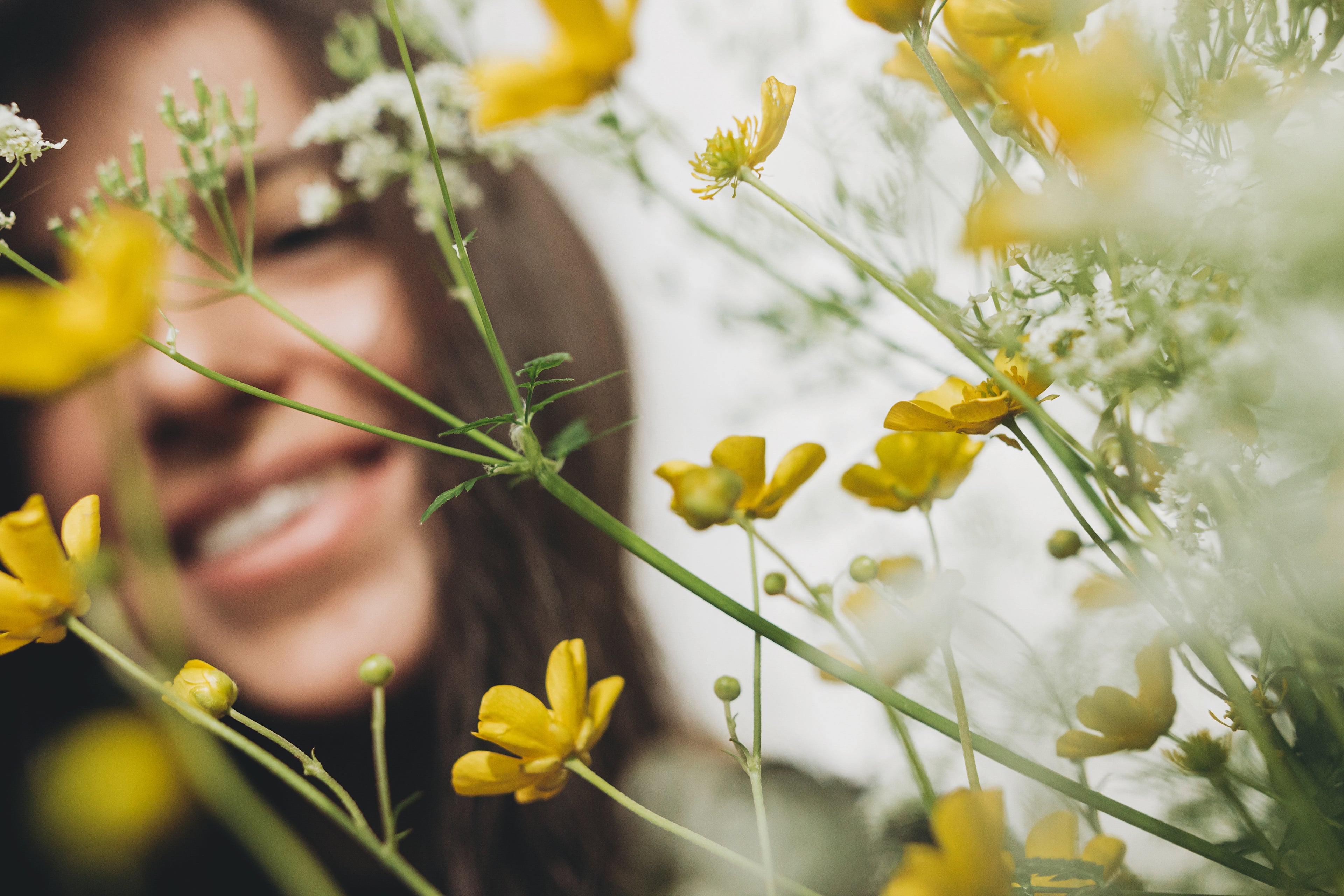 Happy woman among beautiful yellow flowers.